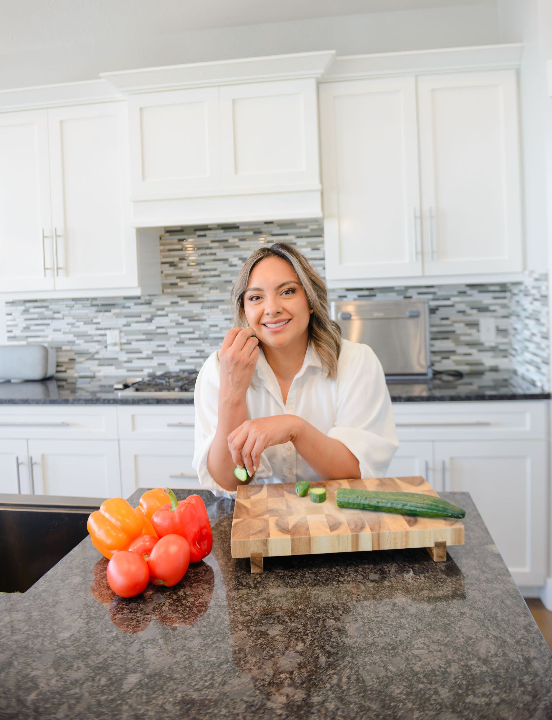A woman with fresh vegetables in a bright kitchen